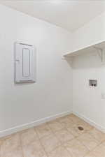 Clothes washing area featuring light tile patterned floors and hookup for a washing machine