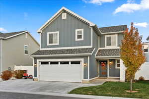 View of front of property featuring a garage and a front yard