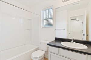 Full bathroom with vanity, bathtub / shower combination, and toilet