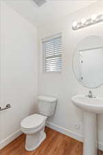 Bathroom featuring wood-type flooring and toilet