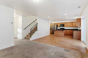 Kitchen featuring black appliances, a center island, and light hardwood / wood-style flooring