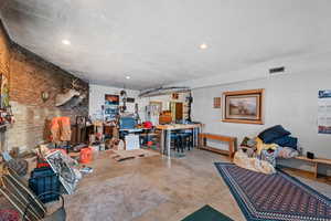 Interior space with a workshop area, concrete flooring, and brick wall