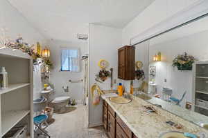 Bathroom featuring vanity, tile patterned floors, a textured ceiling, and toilet