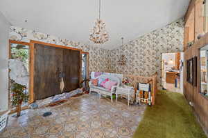 Unfurnished room with vaulted ceiling, a textured ceiling, and a notable chandelier