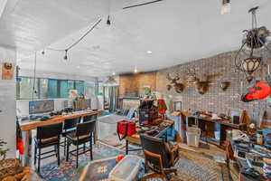 Interior space with a textured ceiling, brick wall, and concrete floors