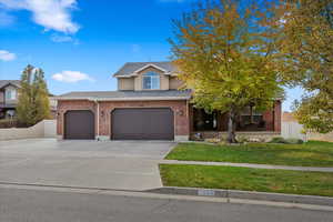 View of front facade featuring a front yard and a garage