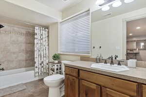 Full bathroom with tile patterned flooring, shower / tub combo, vanity, and toilet