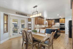 Dining room featuring french doors, light hardwood / wood-style flooring, and sink