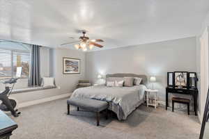 Bedroom with carpet, a textured ceiling, and ceiling fan