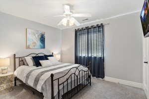 Carpeted bedroom featuring ceiling fan