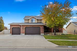 View of front of house with a garage and a front lawn