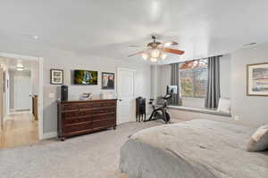 Carpeted bedroom featuring ceiling fan