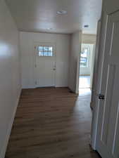 Entrance foyer featuring dark hardwood / wood-style flooring and a textured ceiling