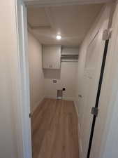 Laundry room with light hardwood / wood-style floors, cabinets, and hookup for a washing machine