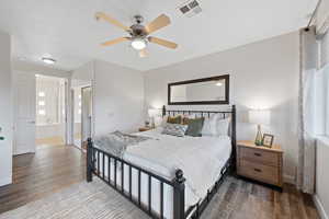 Bedroom featuring ensuite bath, ceiling fan, and wood-type flooring