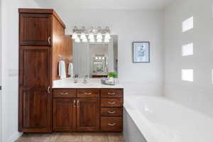 Bathroom with a bathing tub, tile patterned flooring, and vanity