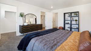 Carpeted bedroom with a spacious closet and a closet