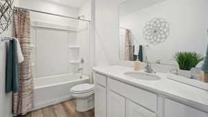 Full bathroom featuring hardwood / wood-style floors, vanity, toilet, and shower / bath combo with shower curtain