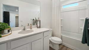 Full bathroom with vanity, toilet, wood-type flooring, and bathtub / shower combination