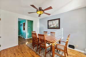 Dining area with ceiling fan and wood-type flooring