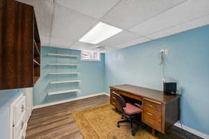 Office with a paneled ceiling and dark hardwood / wood-style floors