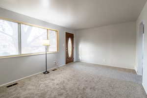 Spare room with light colored carpet and a wealth of natural light