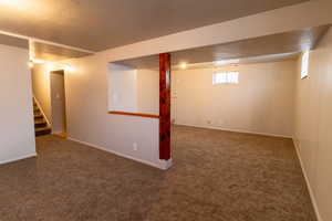 Basement featuring carpet flooring and a textured ceiling