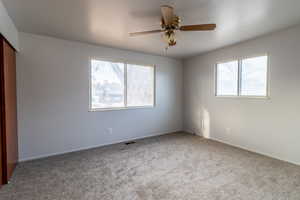 Carpeted empty room with ceiling fan