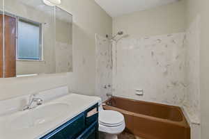 Full bathroom featuring vanity, toilet, washtub / shower combination, and a textured ceiling