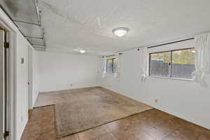 Carpeted spare room featuring a textured ceiling