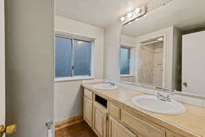 Bathroom with tile patterned floors, vanity, and a textured ceiling