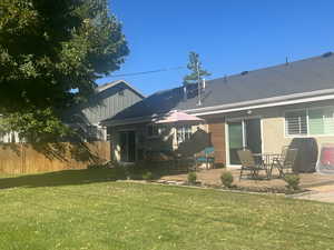 Back of property featuring a lawn and a patio