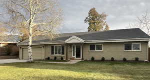 Ranch-style home with a garage and a front lawn