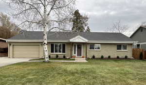 Single story home with a front yard and a garage