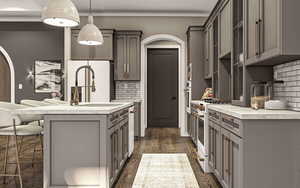 Kitchen featuring decorative backsplash, gray cabinetry, white appliances, dark wood-type flooring, and hanging light fixtures