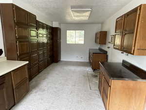 Kitchen featuring light carpet and a textured ceiling