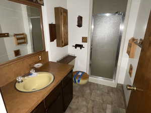 Bathroom with vanity, toilet, and a shower with shower door