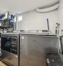 Laundry area featuring washing machine and clothes dryer and wood-type flooring