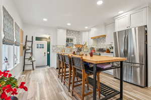 Kitchen featuring white cabinetry, light wood-type flooring, and appliances with stainless steel finishes