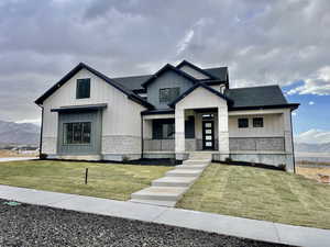 View of front of property featuring covered porch, a mountain view, and a front lawn