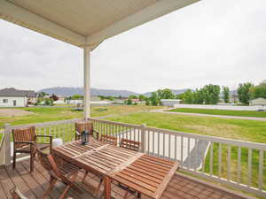 Covered Deck featuring a mountain view and a lawn