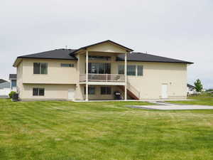 Rear view of house with a lawn and cooling unit