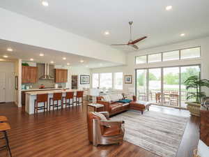 Living room with ceiling fan and dark wood-type flooring