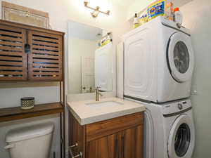 Clothes washing area with stacked washer and clothes dryer and sink