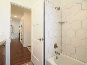 Bathroom featuring hardwood / wood-style flooring and tiled shower / bath