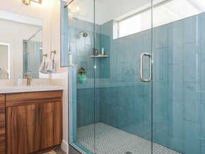 Mather Bathroom with tile patterned flooring, vanity, and a shower with shower door