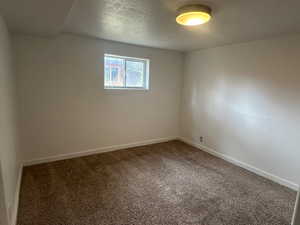 Carpeted empty room with a textured ceiling