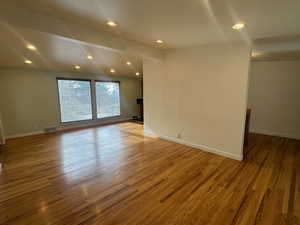 Spare room with beam ceiling and wood-type flooring