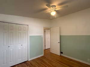 Unfurnished bedroom featuring a closet, ceiling fan, and dark hardwood / wood-style flooring