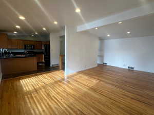 Kitchen featuring black refrigerator, lofted ceiling with beams, dark hardwood / wood-style floors, and sink